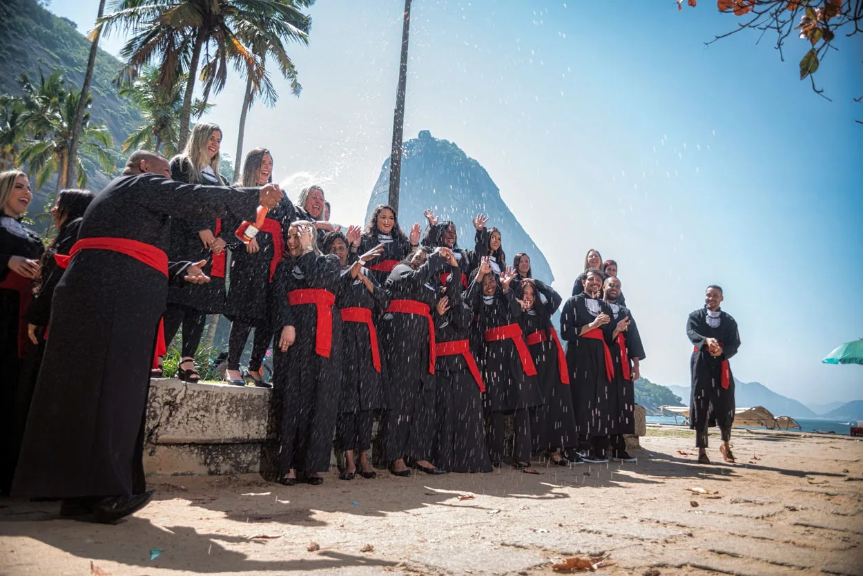 Turma de formandos comemora na praia com o Pão de Açúcar ao fundo