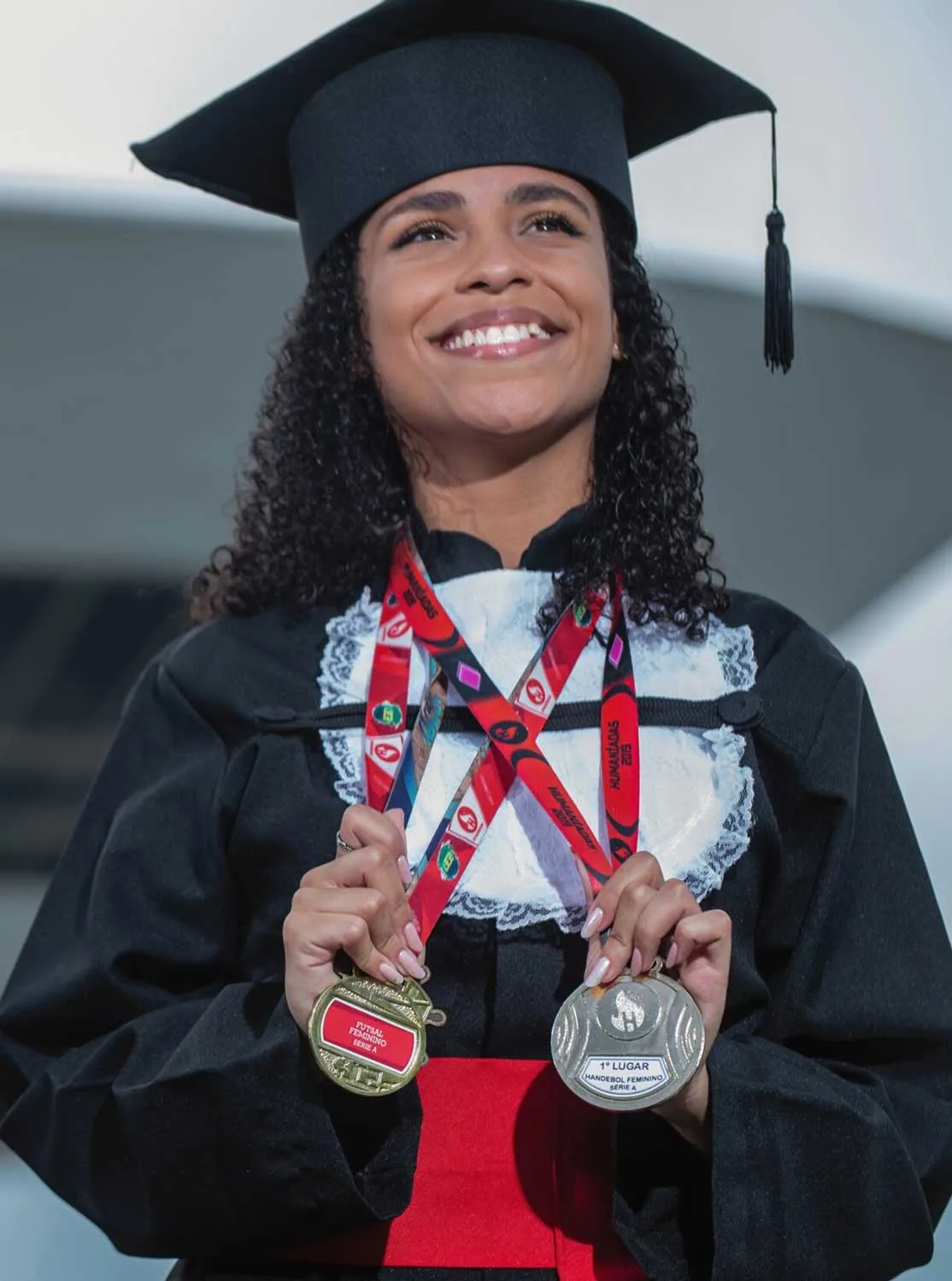 Formanda de beca segura medalhas em ensaio de formatura no MAC de Niterói