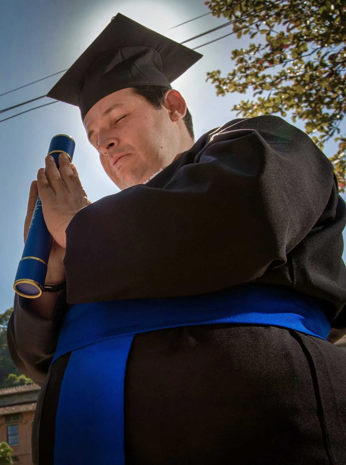 Formando de beca olha para o horizonte em ensaio de formatura em Paracambi