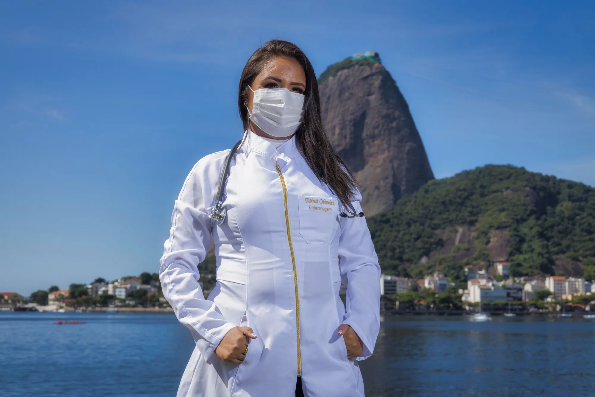 Estudante de jaleco branco e estetoscópio diante do Pão de Açúcar