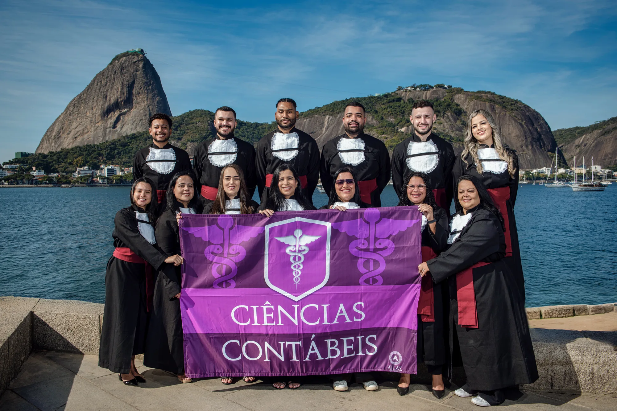 Turma de Ciências Contábeis com a bandeira do curso diante do Pão de Açúcar