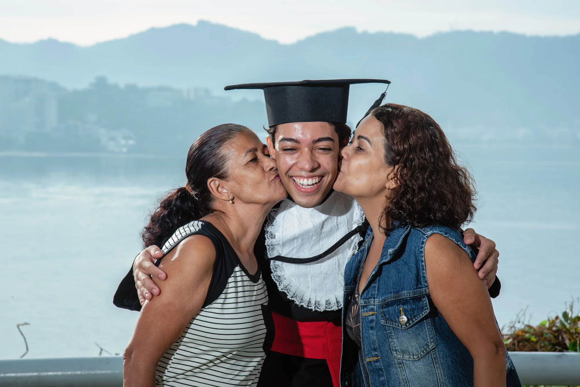 Formando de beca recebe beijos da mãe e da irmã no mirante do MAC de Niterói