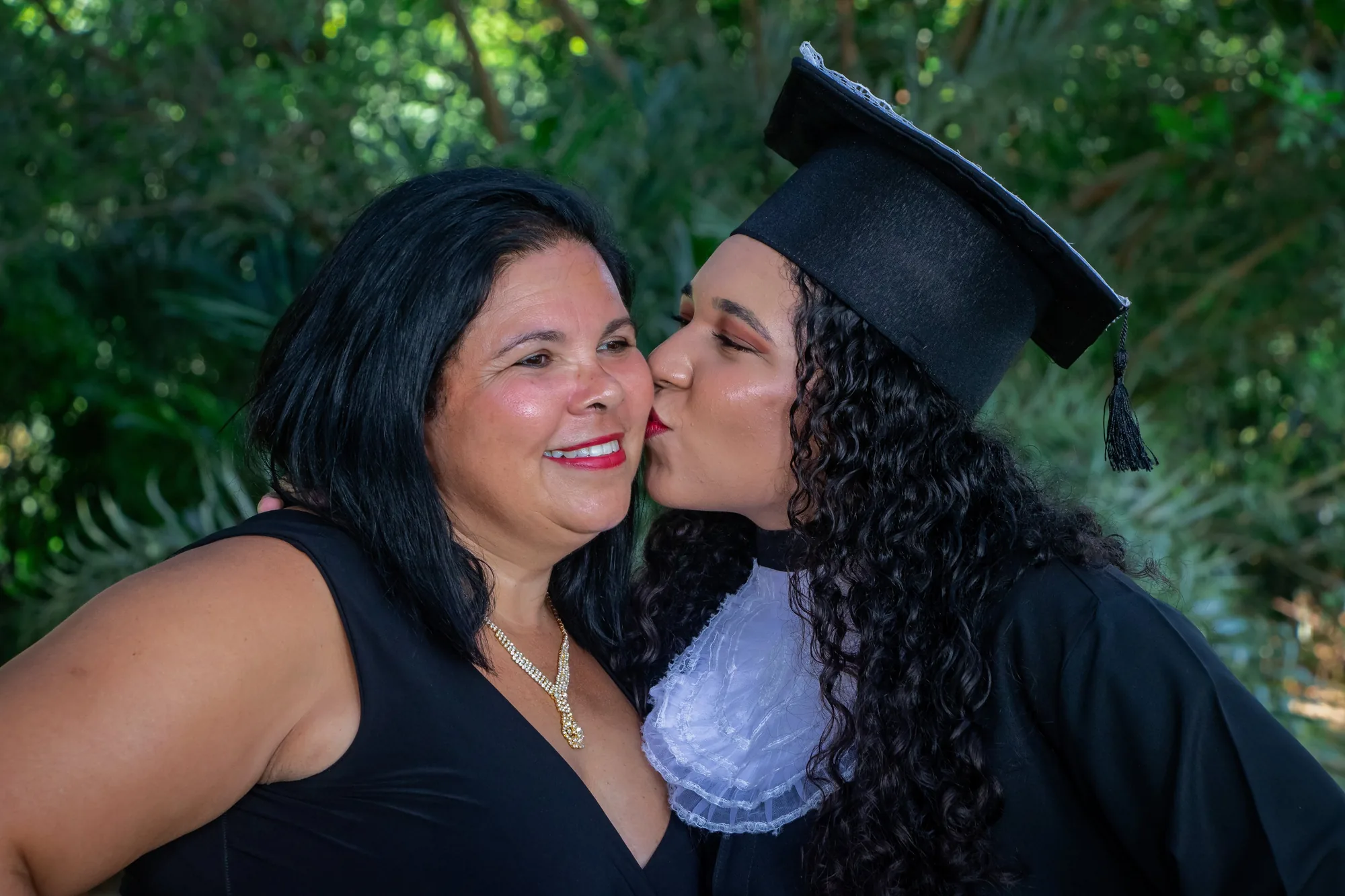Formanda de beca beija o rosto da mãe nos jardins do MAM