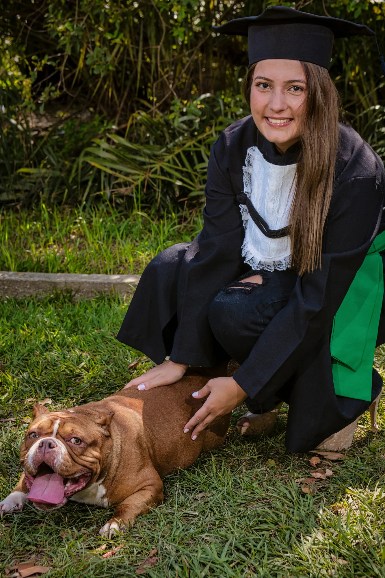 Formanda de beca com o seu cachorro em ensaio de formatura em Paracambi