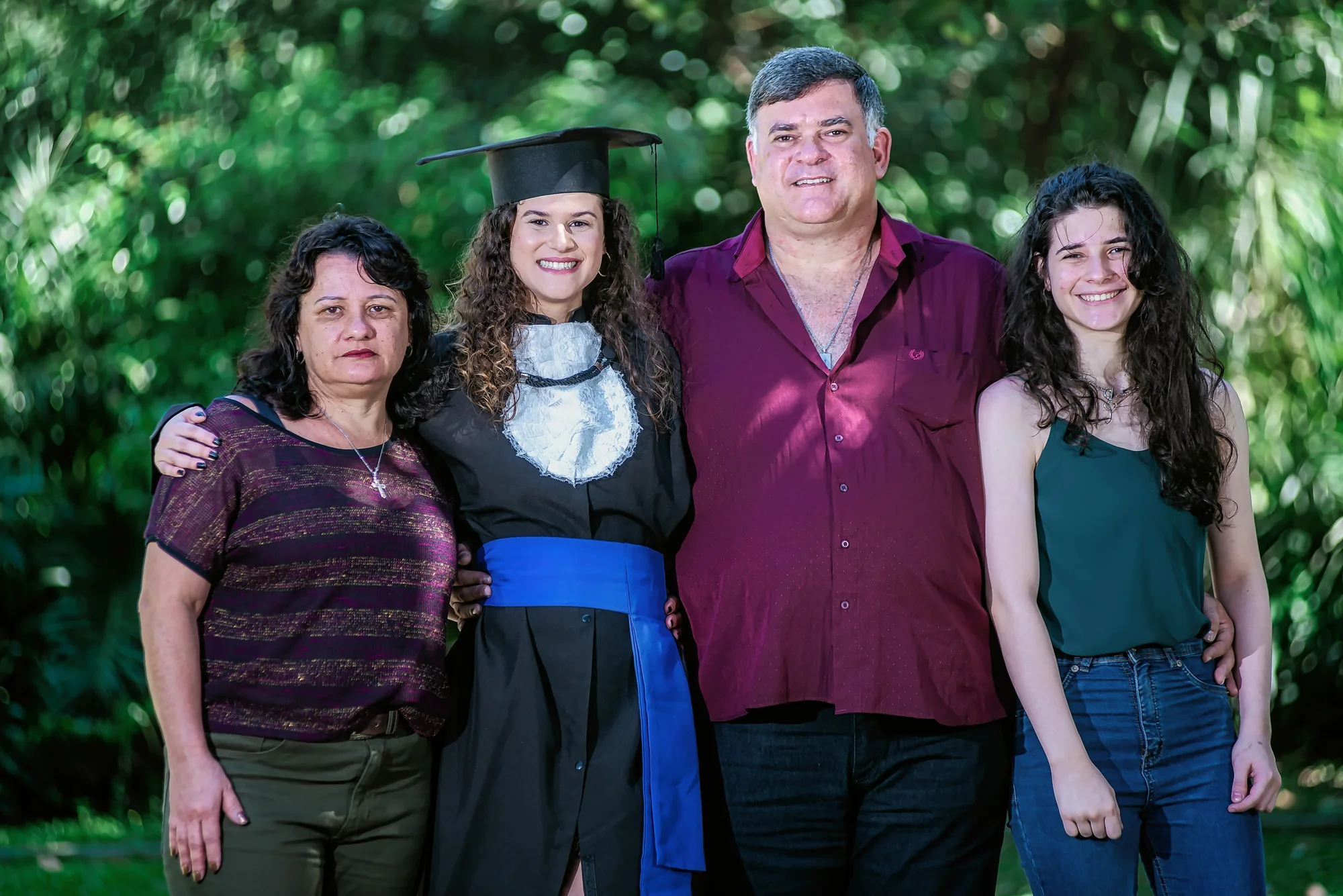 Formanda de beca com a família no campus da UFRJ