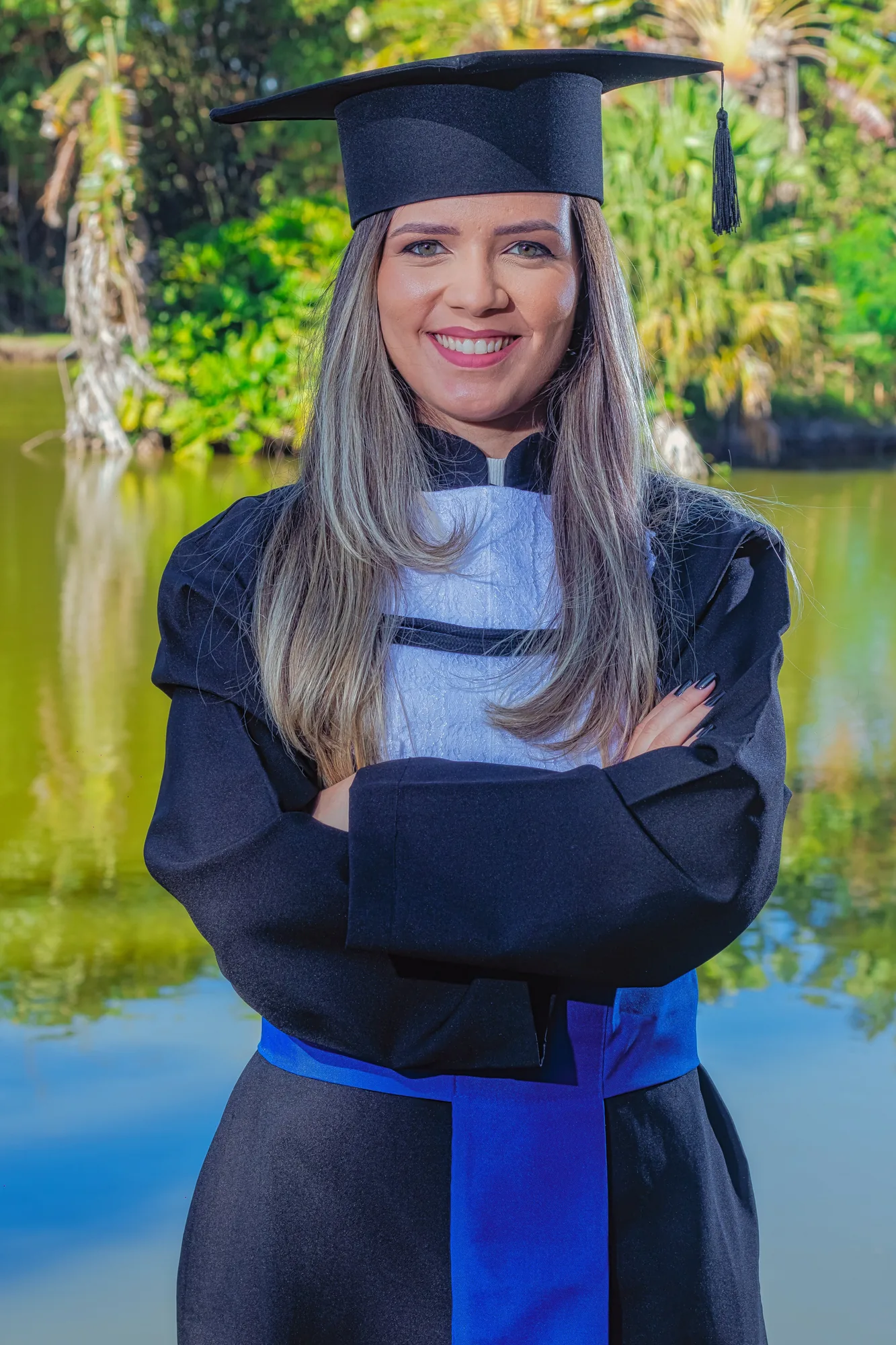 Formanda de beca à beira do lago da UFRRJ, em Seropédica