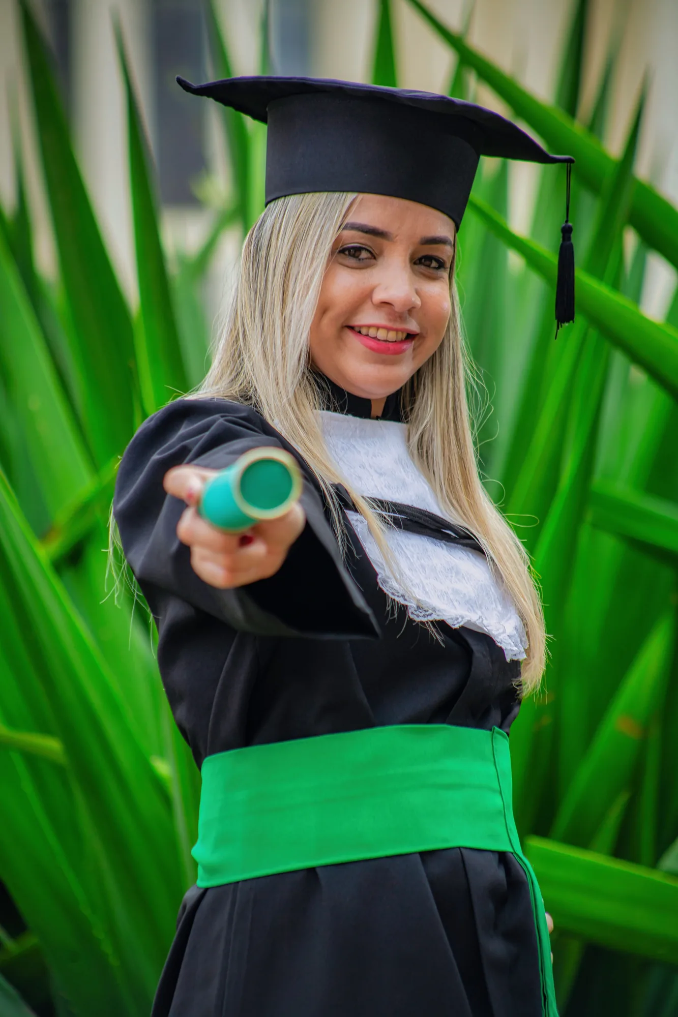 Formanda de beca segura o canudo em ensaio de formatura na Urca