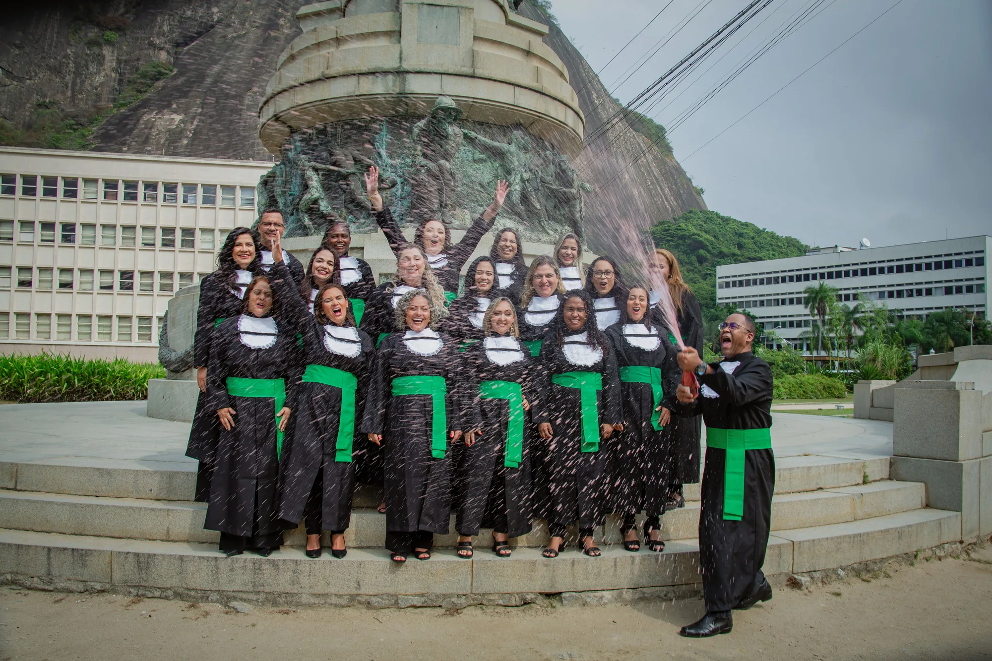 Turma de formandos comemora diante do monumento, na Urca